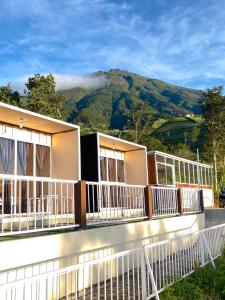 a building with balconies with a mountain in the background at Cepogo Cabin Mangli Cabin Keluarga & Syariah in Prampelan