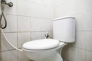 a white toilet in a bathroom with a shower at RedDoorz Syariah at Sakinah Family Tulungagung in Tulungagung