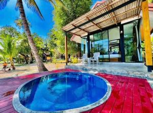 a swimming pool in the middle of a backyard with a villa at Mook Tamarind Resort in Ko Mook