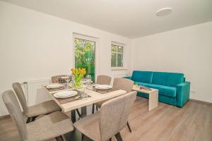 a dining room with a table and a blue couch at BSW Ferienwohnungen Hiddensee in Hiddensee