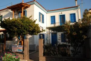 a white house with blue doors and trees in front of it at Studios Julia in Petra