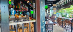 a bar with chairs and tables in a restaurant at Suria Suites Apartment & Guesthouse in Tanah Rata