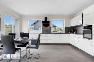 a kitchen with white cabinets and a table and chairs at Ferienwohnung Bresser Bernsteinsee in Sassenburg +23 photos