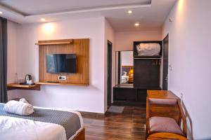 a bedroom with a bed and a desk and a tv at Hardys Retreat in Mai Jūbar