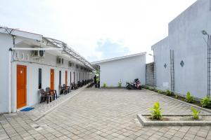 a courtyard of a building with a man standing in the distance at RedDoorz Syariah at Joa Homestay Goodean Sleman Yogyakarta in Godean