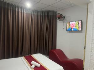 a room with a bed and a tv on the wall at Hồng Phát 68 Hotel in Ho Chi Minh City