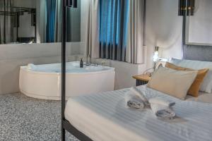 a bathroom with a tub and a bed and a sink at Hotel Nuvò in Naples