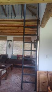 a loft bed in a room with a couch at El descanso tiene nombre: Sonko in Tafí del Valle