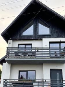 a black and white house with a balcony at New Generation in Borsec