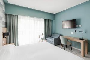 a bedroom with a bed and a desk and a chair at Aldiana Club Rocca Nettuno Calabria in Tropea