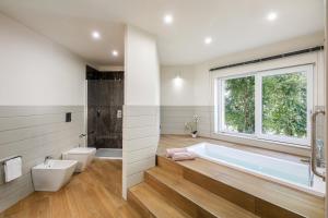 a bathroom with a tub and a toilet and a window at Aldiana Club Rocca Nettuno Calabria in Tropea