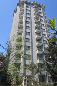 a tall apartment building with trees in front of it at Kule Apart in Trabzon