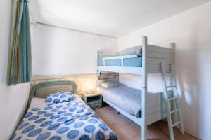 Un dormitorio con dos literas y una cama. en Studio de Mammo, en Osani