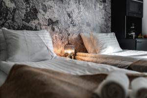 two beds and a couch in a bedroom at Hotelli Vaakko - Hotel and Apartments by UHANDA in Tampere +2 photos