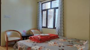 a bedroom with a bed with a red pillow on it at Bhagsunag Nizu Palace in McLeod Ganj