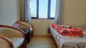 a room with two beds and two chairs and a window at Bhagsunag Nizu Palace in McLeod Ganj +21 photos