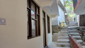 a dog sitting on the steps of a building at Bhagsunag Nizu Palace in McLeod Ganj