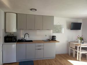 a kitchen with white cabinets and a table at Mogielicki Zakątek in Jurków