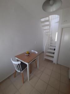 a table and chair in a room with a staircase at Harmony Serifos in Livadion +7 photos