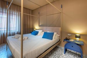 a bedroom with a canopy bed with blue pillows at Hotel Nuvò in Naples