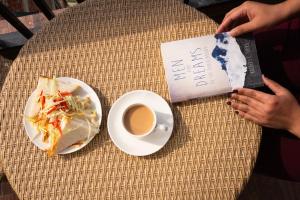a table with a plate of food and a cup of coffee at Hardys Retreat in Mai Jūbar