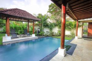 - une piscine dans une cour avec un kiosque dans l'établissement Private Pool Villas Kuta Bali, à Badung