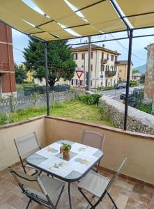 een tafel en stoelen op een balkon met uitzicht op een straat bij Casa Olga in La Spezia