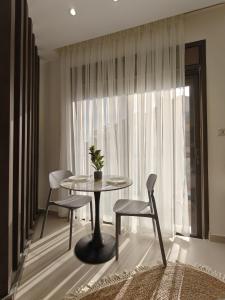 a table and chairs in a room with a window at The sahill stays in Amman