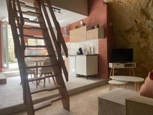 Una sala de estar con una escalera de madera y una cocina. en La Cachette Futuroscope, en Beaumont