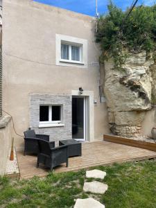 Un patio con sillas y una mesa y un edificio. en La Cachette Futuroscope, en Beaumont