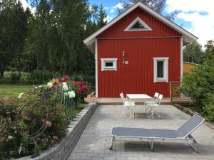 a red house with a table and chairs in front of it at Sjöstuga, lake view cottage in Spersboda
