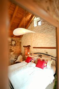 a bedroom with a large bed with red pillows at Agave in Veliko Grablje