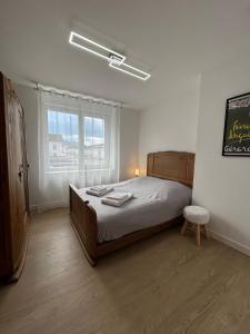 une chambre avec un grand lit et une fenêtre dans l'établissement La Jonquille, Appartement Centre Ville de Gérardmer, linge et ménage inclus, à Gérardmer