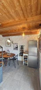 a kitchen with a table and a stainless steel refrigerator at Agave in Veliko Grablje