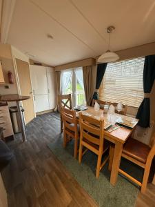 a kitchen and dining room with a table and chairs at Lovely Serenity 1 and 2 caravans are situated on the Norfolk Broads in Lowestoft