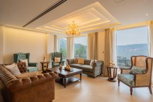 un soggiorno con divani, sedie e lampadario pendente di ELIVAAS privé Royce Cottage Hilltop 4 BHK Retreat With Indoor Bar, Terrace & Scenic Views a Kasauli
