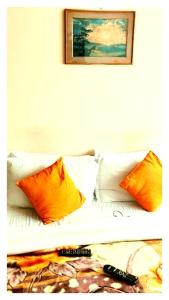 a couch with four pillows and a picture on the wall at Hotal North 4 Star darjeeling in Darjeeling