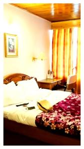 a hotel room with a bed with a book on it at Hotal North 4 Star darjeeling in Darjeeling