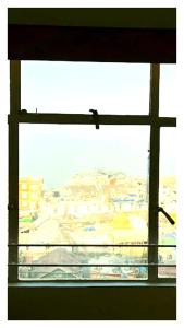 a window with a view of a city at Hotal North 4 Star darjeeling in Darjeeling