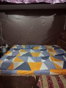 a bed with a colorful quilt on top of it at Shaida Homestay in Dāsna