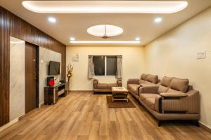 a living room with a couch and a tv at Newly Renovated-Farm Villa -6BHK with Pool & Turf in Lonavala