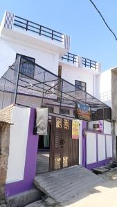a purple and white building with a gate at Maa Bhagwati Home stay & PG House in Ayodhya