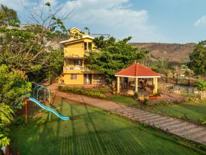 an aerial view of a house with a playground at Newly Renovated-Farm Villa -6BHK with Pool & Turf in Lonavala