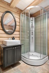 a bathroom with a shower with a sink and a mirror at Large and cozy family cabin with sauna in Trysil
