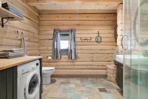 a bathroom with a washer and dryer in a log cabin at Large and cozy family cabin with sauna in Trysil +14 photos