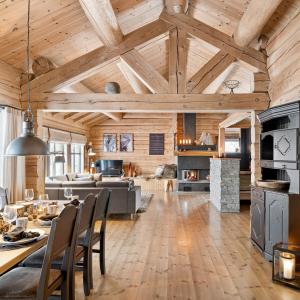 a kitchen and living room with wooden ceilings at Large and cozy family cabin with sauna in Trysil