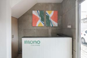 a lobby with two paintings on the wall at Mono Coliving Brotojoyo, Semarang in Stasiun Tawang