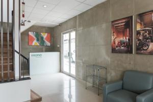 a lobby with a couch and paintings on the wall at Mono Coliving Brotojoyo, Semarang in Stasiun Tawang