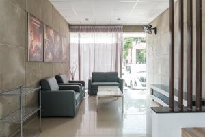 a living room with two chairs and a table at Mono Coliving Brotojoyo, Semarang in Stasiun Tawang +30 photos