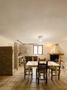 eine Küche und ein Esszimmer mit Tisch und Stühlen in der Unterkunft La Botte e il Vino Rooms in Capoterra + 8 Fotos